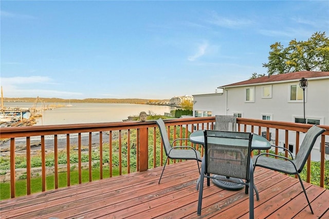 deck featuring outdoor dining area and a water view