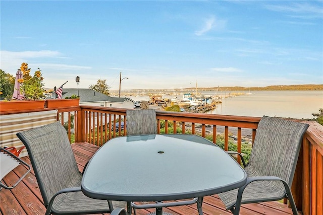 deck featuring a water view and outdoor dining area