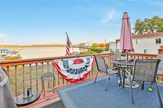 deck featuring outdoor dining area and a water view