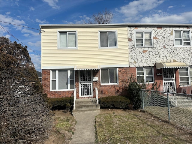 view of property featuring fence and brick siding