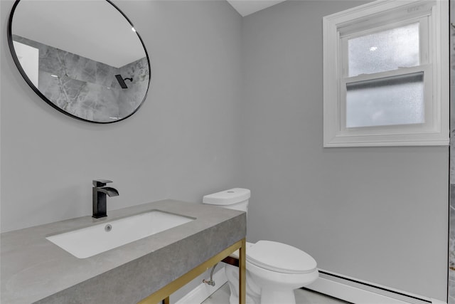 bathroom with baseboard heating, a sink, and toilet