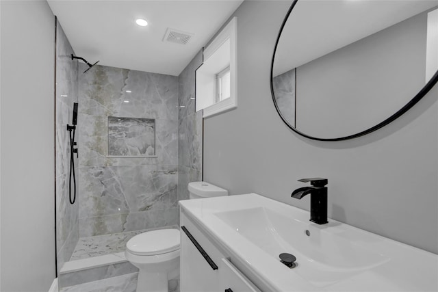 full bath featuring visible vents, tiled shower, toilet, marble finish floor, and vanity