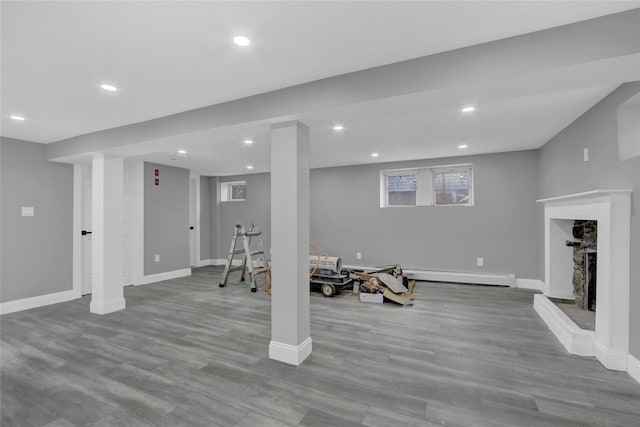 exercise room with a baseboard heating unit, recessed lighting, and wood finished floors