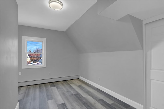 bonus room featuring vaulted ceiling, baseboard heating, wood finished floors, and baseboards