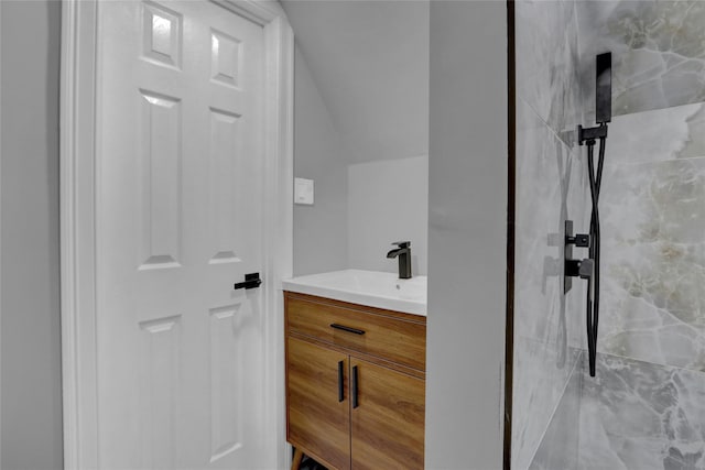 bathroom featuring vaulted ceiling, vanity, and walk in shower