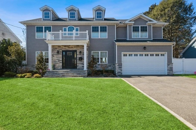 view of front of house with a balcony, stone siding, a garage, and a front lawn