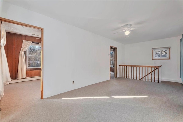 empty room with baseboard heating, carpet flooring, and ceiling fan