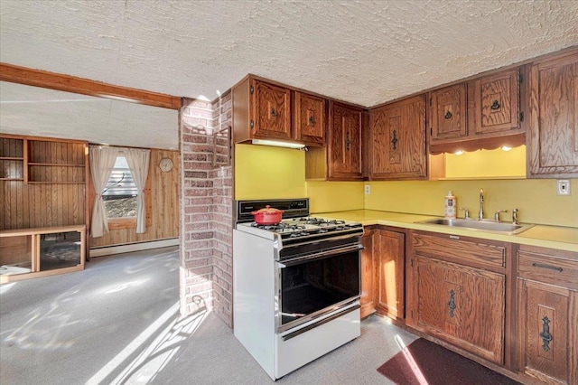 kitchen with white gas range, baseboard heating, a textured ceiling, and a sink