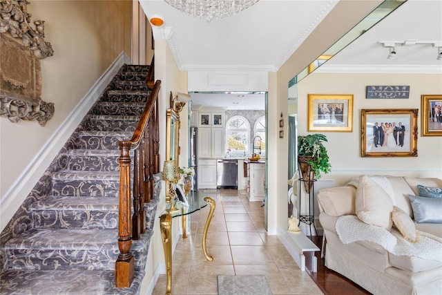 foyer with light tile patterned floors, baseboards, stairway, ornamental molding, and rail lighting