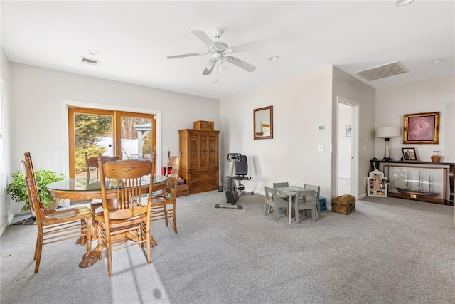 dining area with ceiling fan, visible vents, and light colored carpet