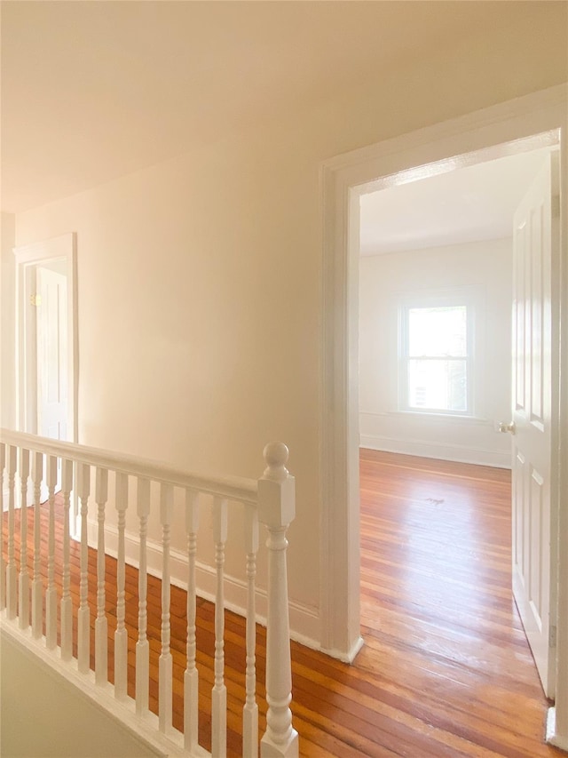 corridor with light wood finished floors and baseboards