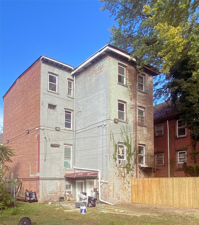 back of property featuring brick siding and fence