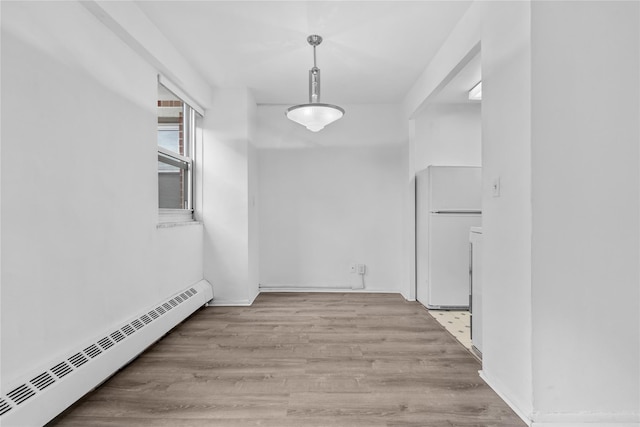 hallway featuring a baseboard radiator and wood finished floors