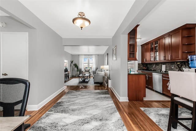 kitchen with dark countertops, open floor plan, stainless steel dishwasher, open shelves, and backsplash