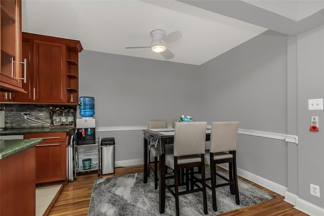 dining space with ceiling fan, wood finished floors, and baseboards