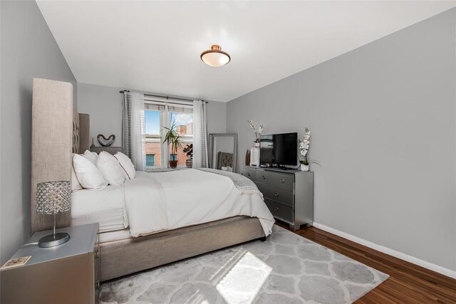 bedroom with baseboards and wood finished floors