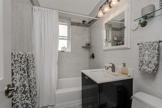 full bath featuring shower / bath combination with curtain, tile walls, toilet, and vanity