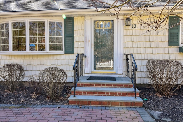 entrance to property featuring a shingled roof