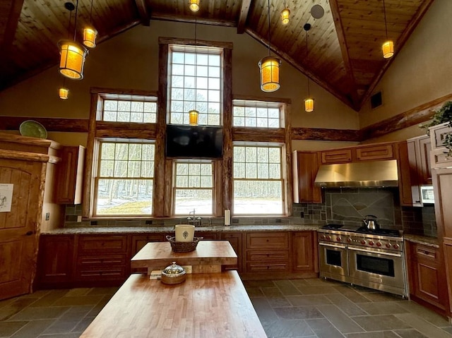 kitchen with range with two ovens, wooden ceiling, under cabinet range hood, wooden counters, and decorative backsplash