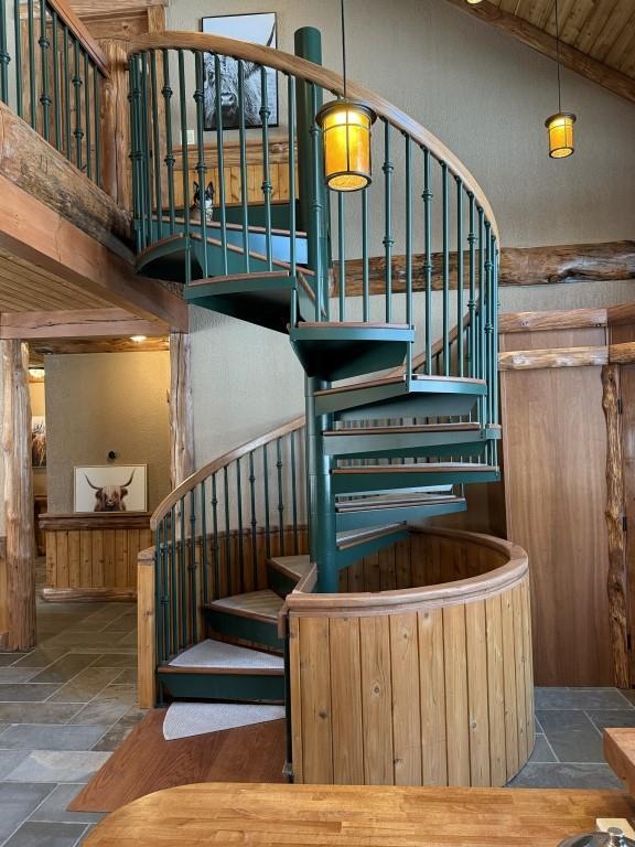 staircase featuring lofted ceiling and stone tile flooring