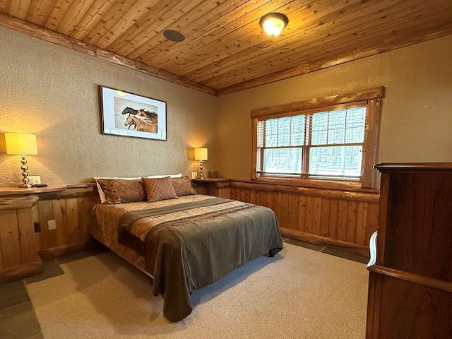 carpeted bedroom featuring a textured wall, wood ceiling, wainscoting, and wood walls