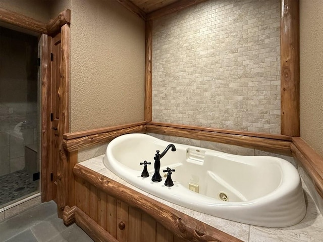 full bath featuring a textured wall, a shower stall, and a whirlpool tub