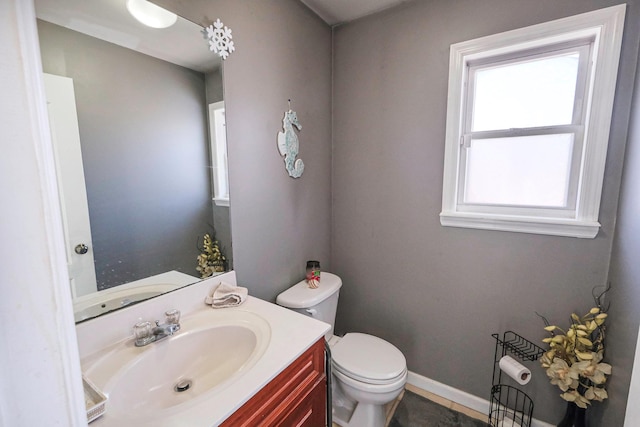 bathroom with vanity, toilet, and baseboards