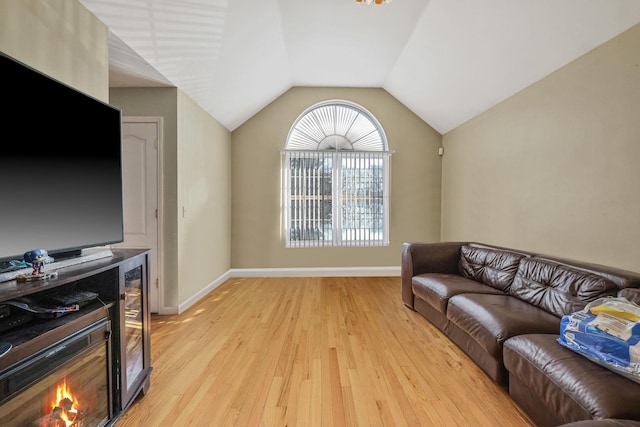 living room featuring light wood-type flooring, lofted ceiling, and baseboards