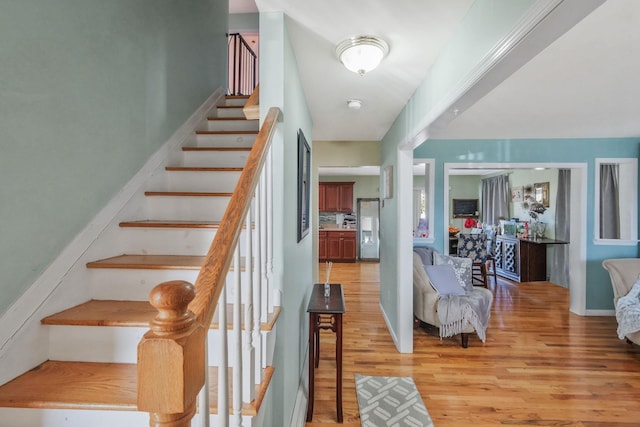 stairs with baseboards and wood finished floors