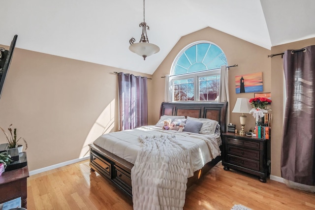 bedroom featuring lofted ceiling, light wood-style flooring, and baseboards