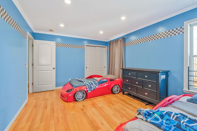 bedroom with crown molding, multiple windows, baseboards, and wood finished floors