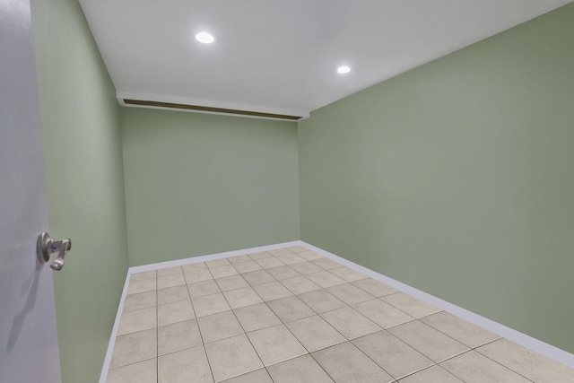 spare room with recessed lighting and baseboards