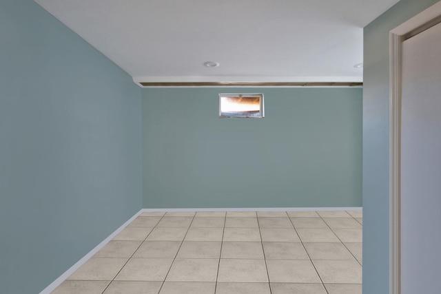 spare room featuring light tile patterned floors and baseboards