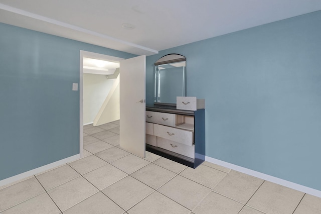 unfurnished bedroom featuring tile patterned flooring and baseboards