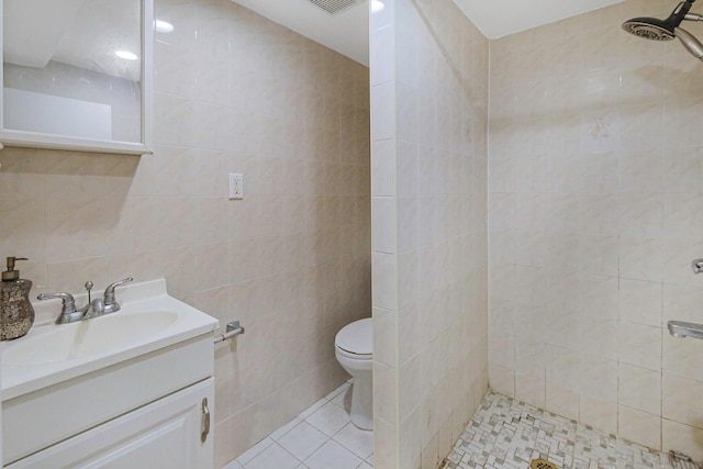 full bathroom featuring a tile shower, tile walls, and toilet