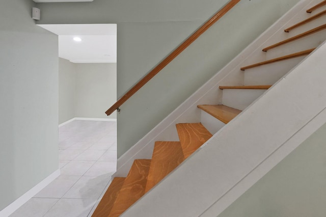 stairs with baseboards and tile patterned floors