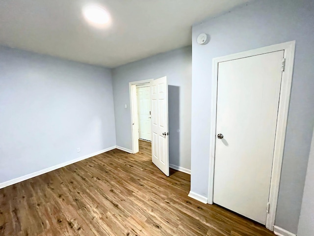 unfurnished bedroom with baseboards and wood finished floors