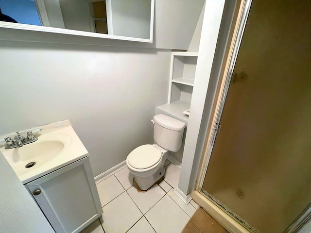 bathroom featuring vanity, a shower stall, toilet, and tile patterned floors