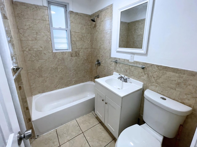 full bath featuring tile walls, toilet, washtub / shower combination, vanity, and tile patterned flooring