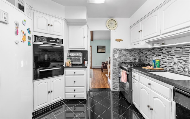 kitchen with stainless steel gas range oven, oven, a sink, a warming drawer, and dark countertops