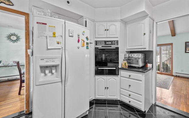 kitchen featuring a toaster, white refrigerator with ice dispenser, dark countertops, white cabinetry, and a warming drawer