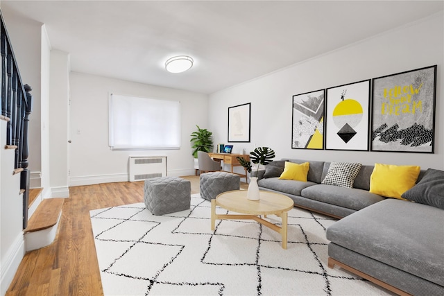 living area featuring heating unit, baseboards, and wood finished floors