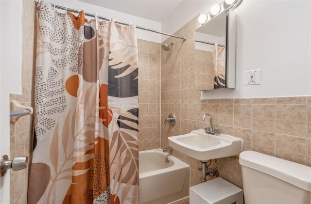 full bathroom featuring a sink, shower / tub combo with curtain, tile walls, and toilet