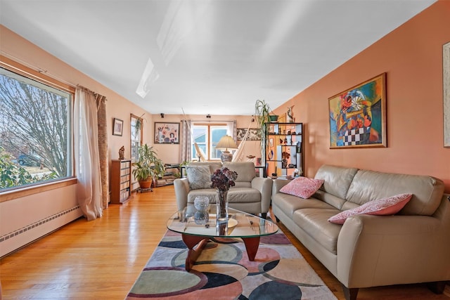 living room featuring a baseboard heating unit and light wood finished floors