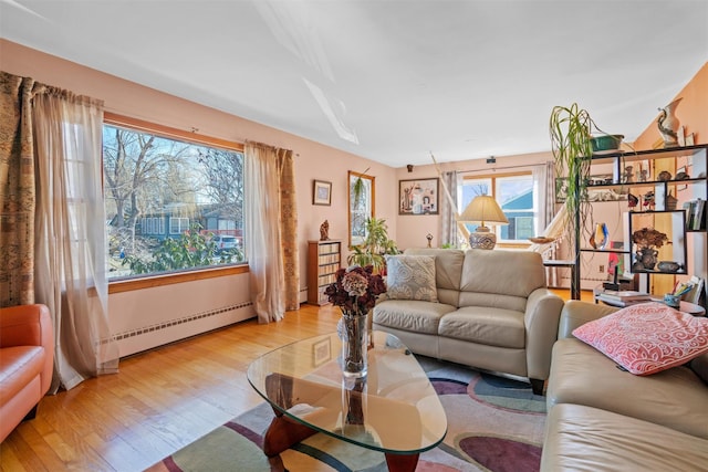 living room with light wood-type flooring and a baseboard radiator