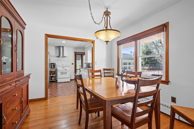 dining room featuring light wood-type flooring and baseboards