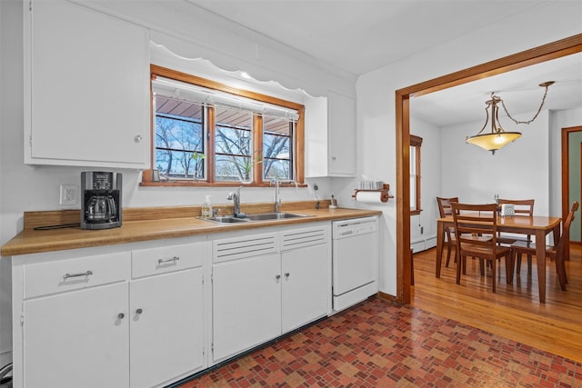 kitchen with white dishwasher, white cabinets, a sink, and light countertops