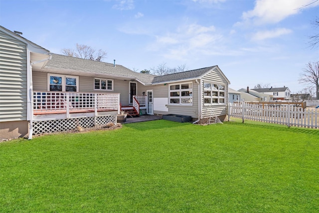 back of house with fence, a lawn, and a wooden deck