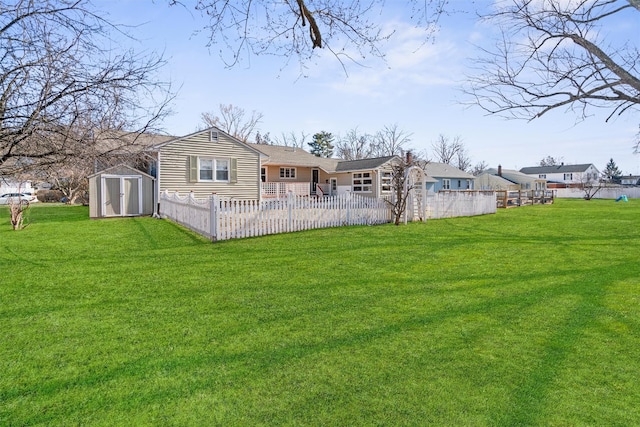 rear view of property featuring fence, a storage unit, a lawn, and an outdoor structure