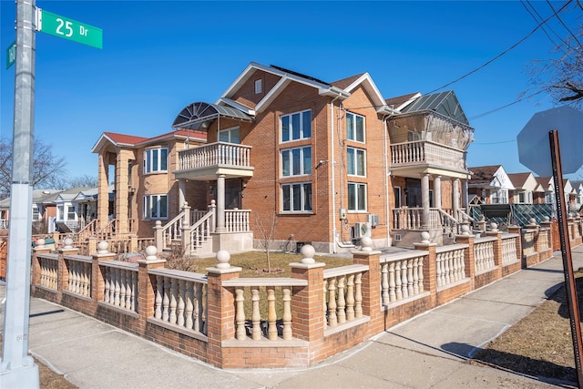 view of front of house with brick siding, fence, and a residential view